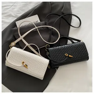 Detail of woven texture shoulder bag with gold knot buckle on grey blazer backdrop