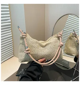 Détail du sac cabas en paille avec anses en cuir rose et décoration de nœuds