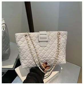 Detail of white quilted leather tote with gold chain strap and elegant square buckle