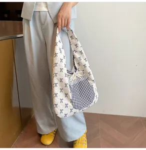 Detail of floral tote bag with blue bow print and drawstring checkered side pocket