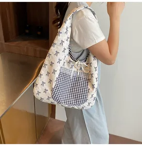 Detail of floral canvas tote bag with blue checkered pocket and white lace trim