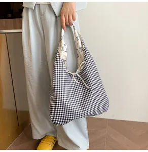 Detail of checkered canvas tote bag with drawstring closure and bow print lining