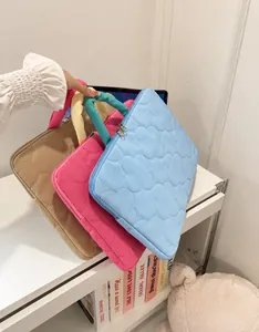 Detail of quilted laptop sleeves in pastel blue and pink with soft carrying handles