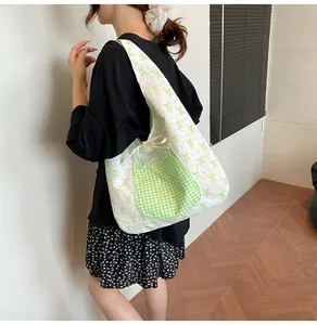 Shoulder tote bag featuring green bow patterns and plaid pocket for daily casual use