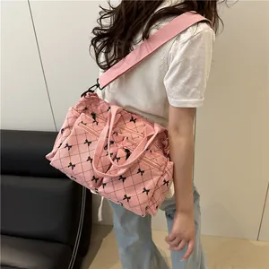 Pink corduroy tote bag with black bows and diamond pattern, stylish quilted shoulder bag