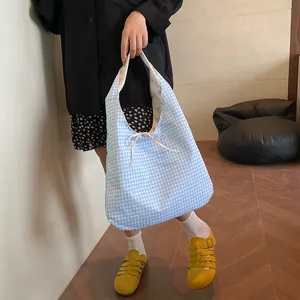 Blue and white plaid reversible tote bag with bow tie closure for summer travel