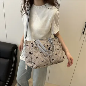 Chic beige corduroy tote bag with black bow lattice pattern and multiple pockets