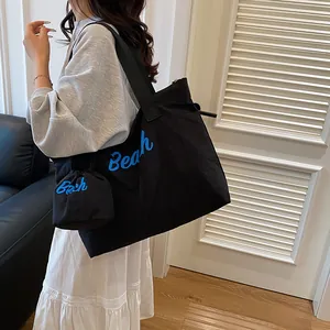 Borsa tote in tela nera con scritta Beach blu e custodia da collo abbinata per donna