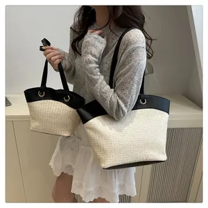 Détails de sacs seaux en paille de deux tailles avec bordure en cuir noir et anneaux dorés