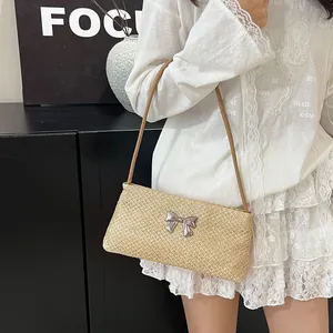 Bolso de hombro minimalista de paja trenzada beige con detalle de lazo plateado