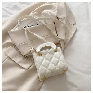 Macro detail of white quilted leather mini bag with gold metal buckles and studs