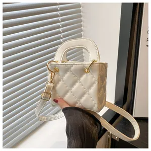 Close-up of a white quilted mini handbag with gold hardware and removable strap