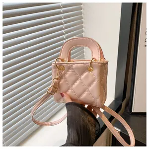 Detailed macro view of pink quilted mini handbag with luxury gold hardware handles