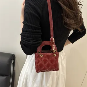 Burgundy quilted leather mini handbag with gold hardware and adjustable crossbody strap
