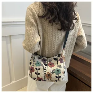 Close-up of jacquard canvas shoulder bag with vintage floral pattern and black strap