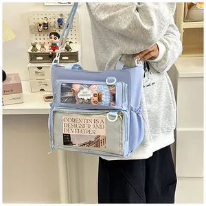 Detail of lavender Ita bag featuring dual transparent pockets for dolls and cards
