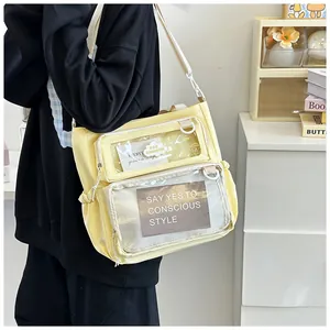Detail of light yellow crossbody ita bag with clear PVC windows and adjustable strap
