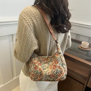 Vintage floral jacquard crescent shoulder bag with adjustable brown strap shown on model