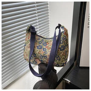 Floral jacquard crescent shoulder bag featuring blue and red flower tapestry pattern
