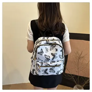 Detail view of the butterfly print nylon backpack shown on model for size and style