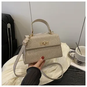 Macro shot of glitter square handbag with golden twist lock and adjustable shoulder strap