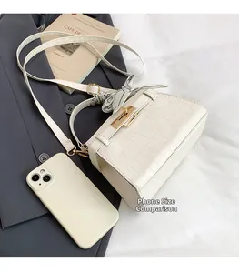 Size comparison between a cream crocodile texture handbag and a smartphone