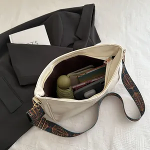 Detail view of the spacious off-white tote interior with a bohemian patterned strap