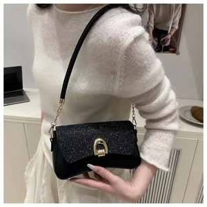 Détail du sac bandoulière noir avec boucle mors dorée et rabat à texture scintillante
