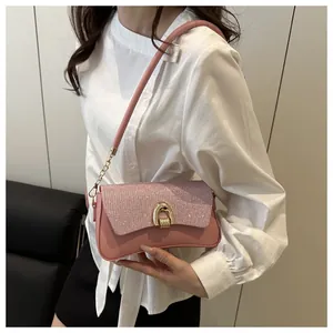 Détail du sac bandoulière rose avec paillettes, boucle fer à cheval dorée et chaîne
