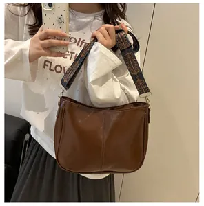 Mirror selfie showing a brown tote bag with a colorful ethnic patterned strap