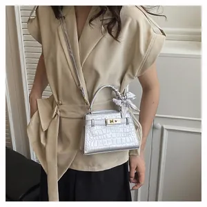 Detailed shot of silver crocodile texture bag with silk scarf handle and gold twist lock
