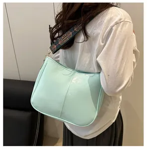 Side view of a mint green tote bag with a vintage colorful embroidered wide strap
