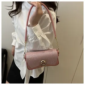 Détail du sac rose scintillant avec boucle fer à cheval dorée et bandoulière