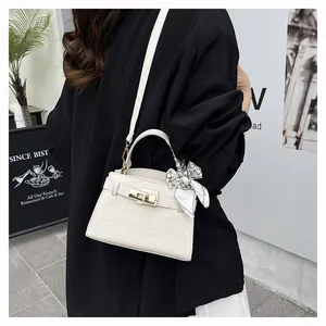 Outdoor street style shot of white crocodile pattern crossbody bag with floral silk scarf