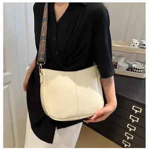 Detail of cream tote bag featuring a vintage pattern wide strap and smooth PU finish