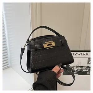 Close-up of black croc-embossed handbag showing golden twist lock and leather texture