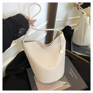 Détail du sac seau en cuir grainé beige avec pendentif en chaîne métallique argentée