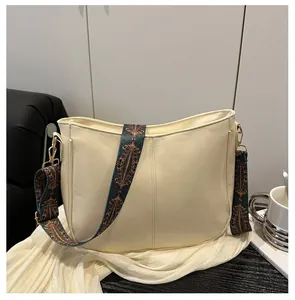 Detail of off-white leather tote with retro patterned strap and gold hardware