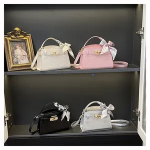 Detail of elegant crocodile pattern mini bags in four colors with silk scarf and gold lock