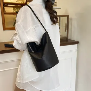 Sac seau minimaliste en cuir noir avec chaîne argentée et fine bandoulière réglable