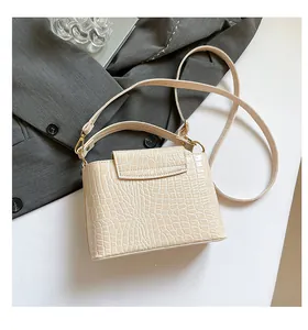 Detailed close-up of cream crocodile pattern tote bag with gold metal hardware
