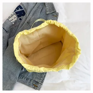 Vista dall'alto della borsa a secchiello gialla in nylon impermeabile con coulisse