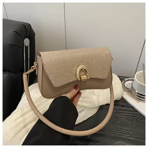 Détail du sac bandoulière couleur thé au lait avec finition pailletée et fermoir fer à cheval