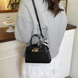 Chic black crocodile-embossed handbag with gold twist lock and printed silk scarf handle