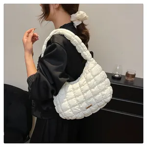 Détail du sac nuage matelassé blanc avec texture souple et plaque en métal doré