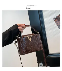 Close-up of brown crocodile texture tote with elegant golden V-logo and handle