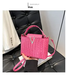 Close-up of bright pink crocodile embossed tote bag with silver V-shaped metal clasp