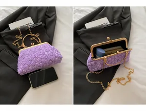 Details der lila Abendtasche mit Blumenmuster, Metallgriff und goldener Kette