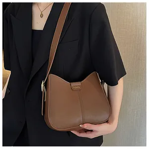 Close-up of the adjustable strap and golden fashion engraving on a brown leather bag