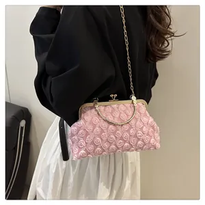Close-up of pink 3D floral texture crossbody bag with gold chain and metal handle